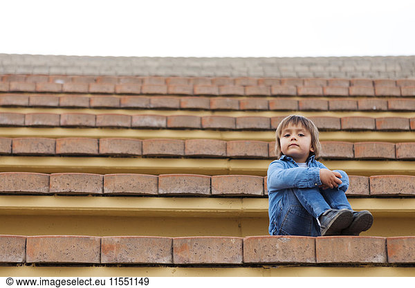 Porträt eines kleinen Jungen auf der Treppe eines Freilichttheaters
