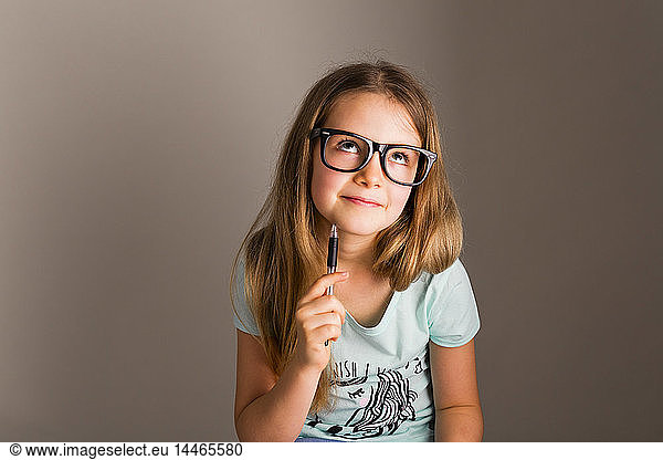 Porträt eines klugen Mädchens mit übergroßer Brille  das denkt