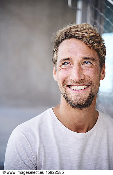 Porträt eines lächelnden jungen Mannes mit weißem T-Shirt