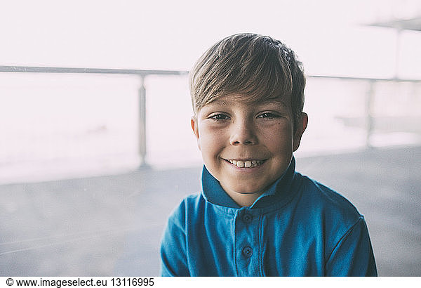 Porträt eines lächelnden Jungen mit blauem T-Shirt
