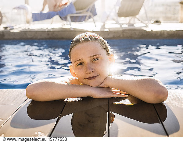 Porträt eines lächelnden Mädchens im Schwimmbad eines Ferienorts