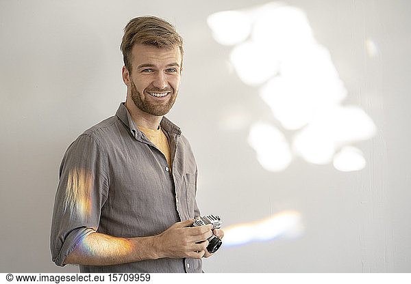 Porträt eines lächelnden Mannes mit altmodischer Kamera