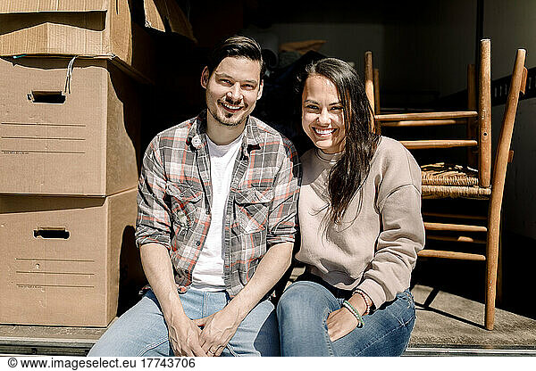 Porträt eines lächelnden Paares  das hinten in einem Lieferwagen sitzt