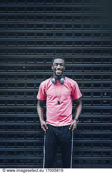 Porträt eines lachenden Mannes mit Kopfhörern und rosa T-Shirt