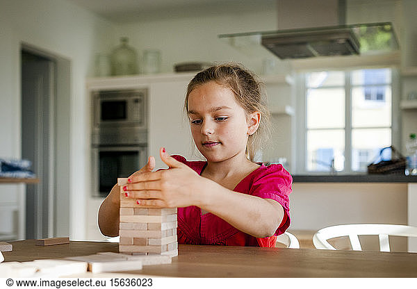 Porträt eines Mädchens  das zu Hause am Tisch spielt