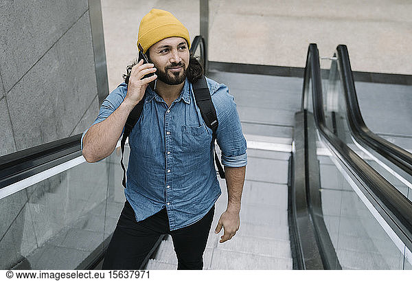 Porträt eines Mannes am Telefon mit Rolltreppe