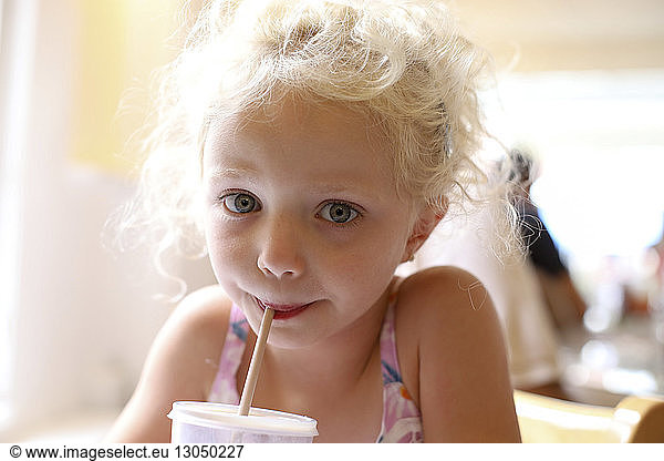 Porträt eines süßen Mädchens bei einem Drink im Restaurant