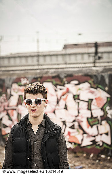 Porträt eines Teenagers mit Sonnenbrille in einem alten  heruntergekommenen Industriegebiet