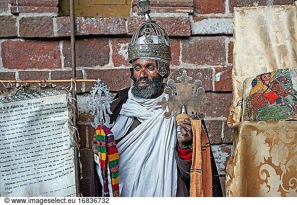 Porträt eines äthiopisch-orthodoxen Priesters mit einem Kreuz in der Höhlenkirche Nakuto Lab  Amhara-Region  Lalibela  Äthiopien.