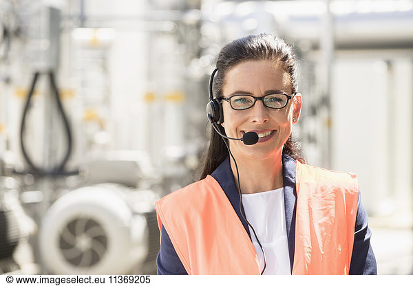 Porträt eines weiblichen Ingenieurs mit Headset und Lächeln in einem geothermischen Kraftwerk