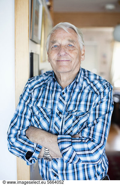 Porträt eines zufriedenen älteren Mannes mit gekreuzten Armen