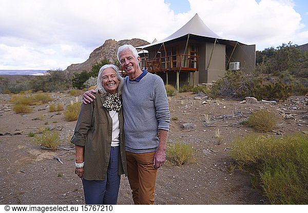 Porträt glückliches älteres Paar vor Safari-Hütte