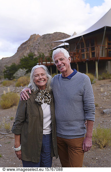 Porträt glückliches älteres Paar vor Safari-Lodge-Hütte