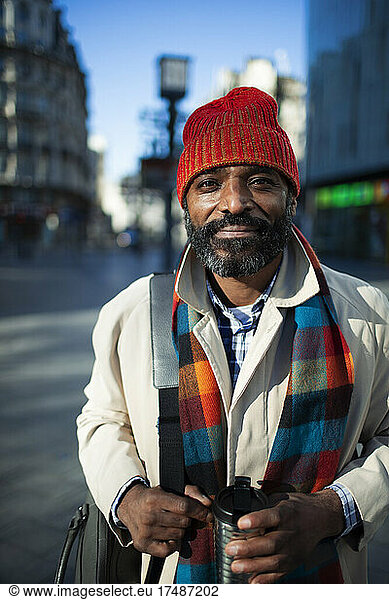 Porträt gut aussehender Geschäftsmann mit Strumpfmütze auf städtischer Straße