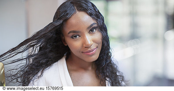 Porträt selbstbewusste schöne junge Frau bürstet langes schwarzes Haar