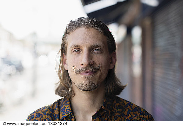 Porträt selbstbewusster junger männlicher Hipster mit Schnurrbart