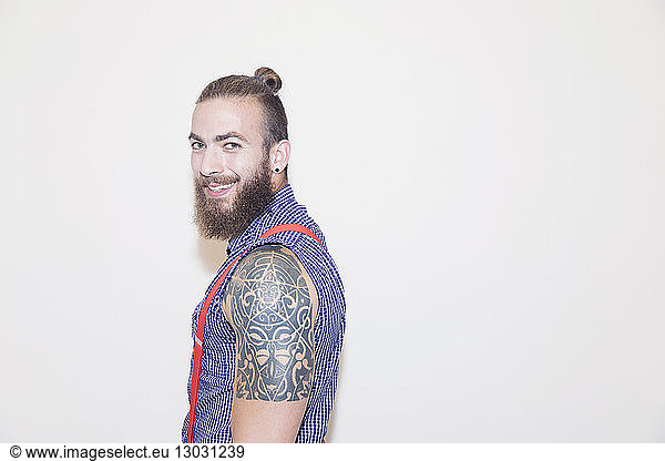 Porträt selbstbewusster männlicher Hipster mit Schultertattoo