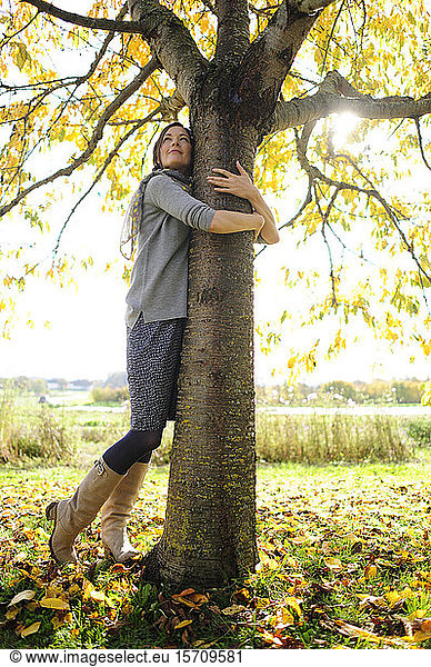 Porträt von Frauen beim Umarmen von Bäumen