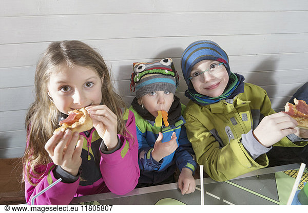 Porträt von Kindern beim Pizzaessen