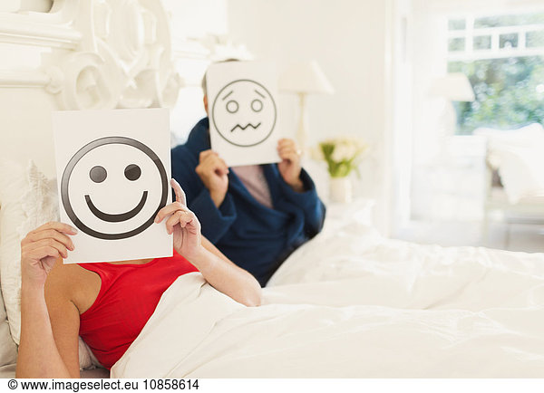 Porträt von Paaren mit lächelndem Gesicht und Stirnrunzeln im Bett