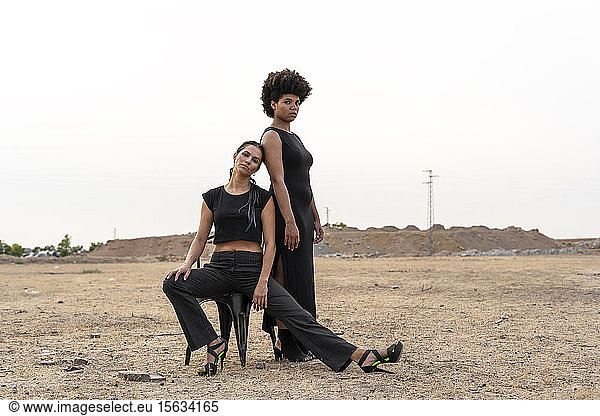 Porträt von zwei schwarz gekleideten Frauen in trostloser Landschaft
