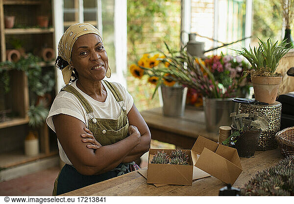 Porträt zuversichtlich weiblichen Florist Boxen Sukkulenten im Laden