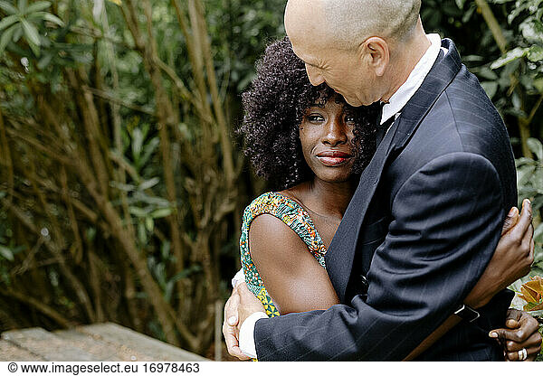 Portrait afro woman looking away being hugged by husband