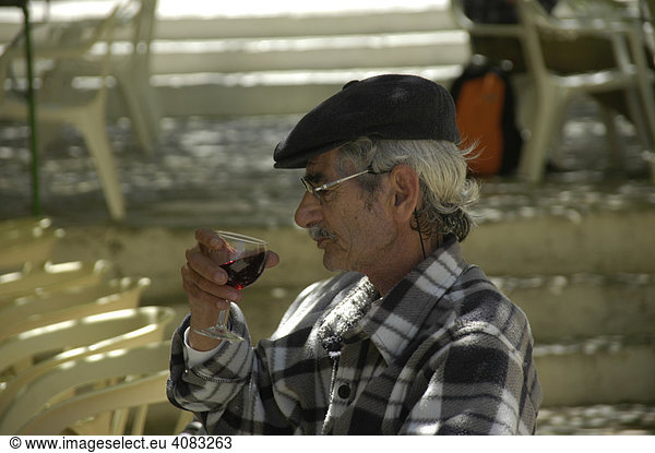 Portrait Alter Mann trinkt ein Glas Rotwein in einer Taverne Insel Symi Griechenland