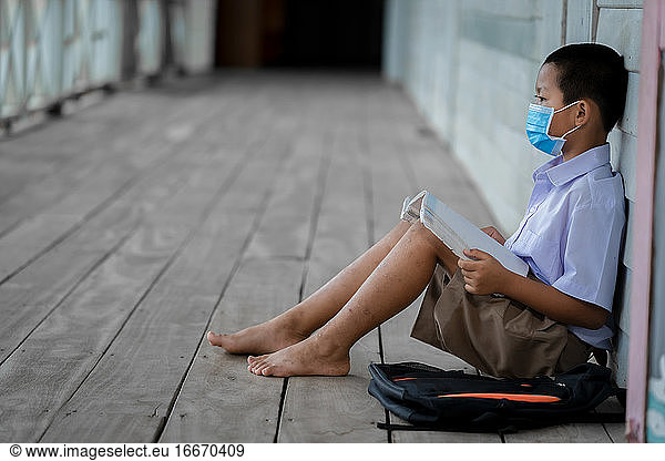 Portrait Asian children student wear face mask sitting at elemen