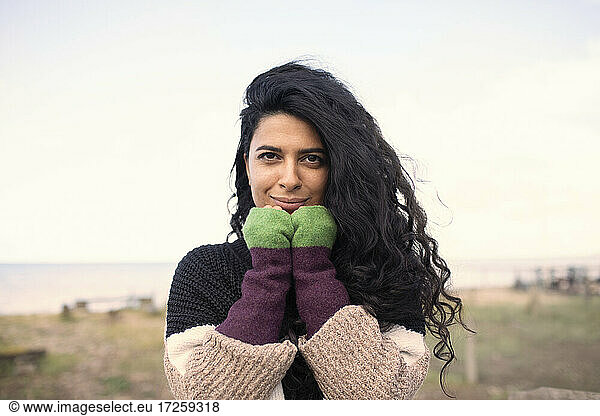 Portrait beautiful woman with long curly black hair on beach