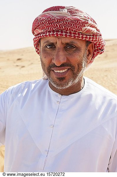Portrait  Bedouin in traditional headgear  sandy desert Rimal Wahiba Sands  Oman  Asia