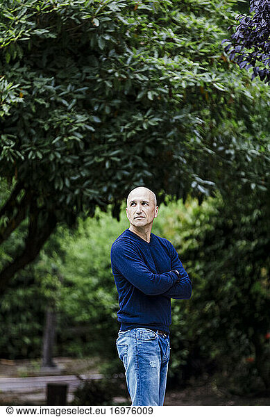 Portrait bold man wearing cashmere outdoor by trees