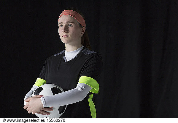 Portrait confident  ambitious teenage girl soccer player holding ball