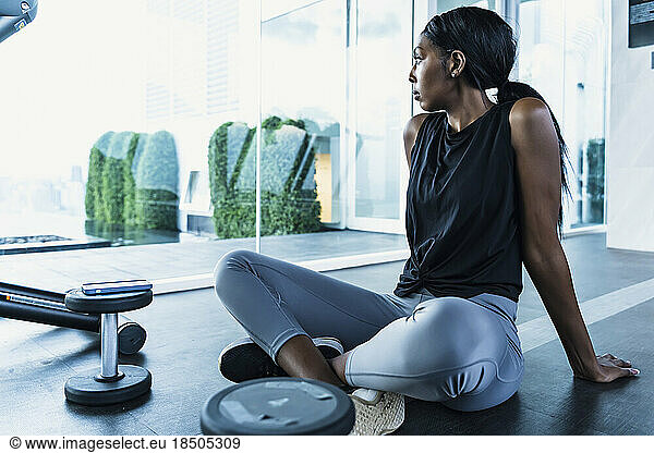 Portrait confident black woman resting at gym