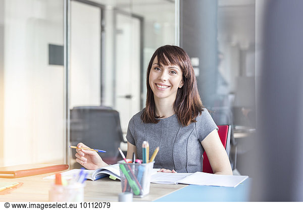 Portrait confident brunette businesswoman working in conference room