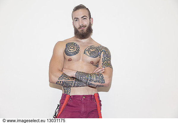 Portrait confident  cool male hipster with bare chest and tattoos