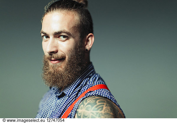 Portrait confident  cool male hipster with beard and shoulder tattoo