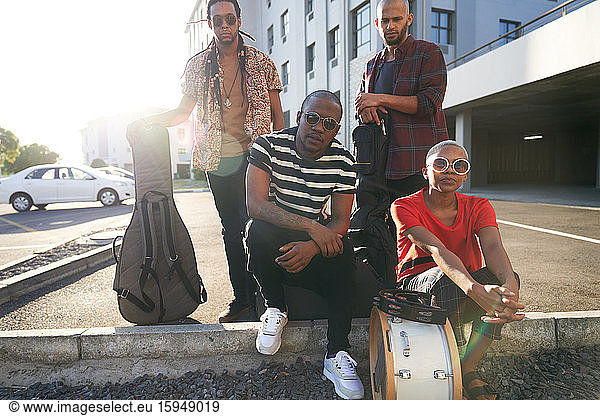 Portrait confident cool musicians in sunny parking lot