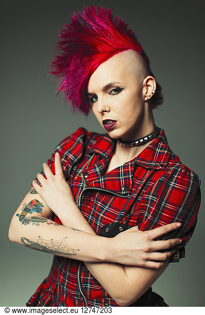 Portrait confident  cool young woman with pink mohawk and tattoos