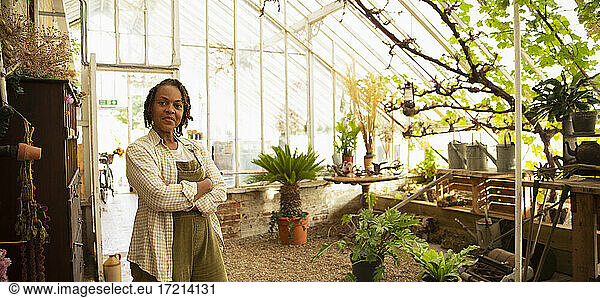 Portrait confident female florist in greenhouse shop