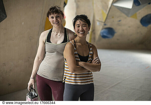 Portrait confident female rock climbers in climbing gym