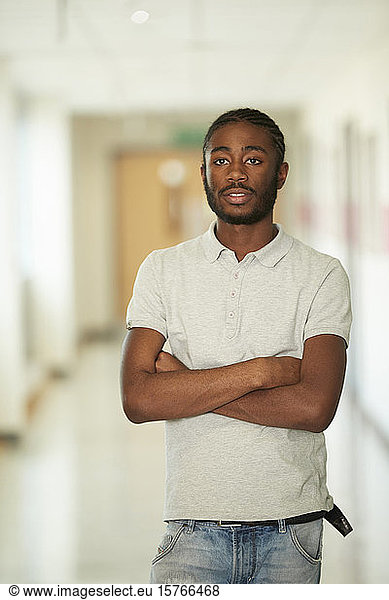 Portrait confident male college student in corridor