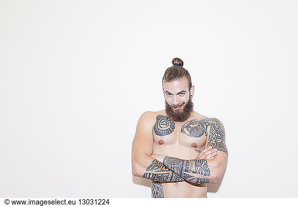 Portrait confident male hipster with bare chest and tattoos