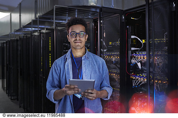 Portrait confident male IT technician with digital tablet in server room