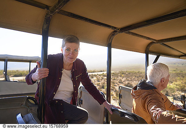Portrait confident mature woman getting into safari off-road vehicle