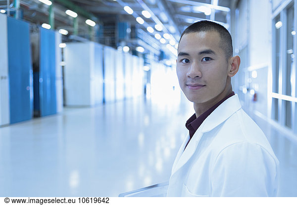 Portrait confident scientist in factory corridor