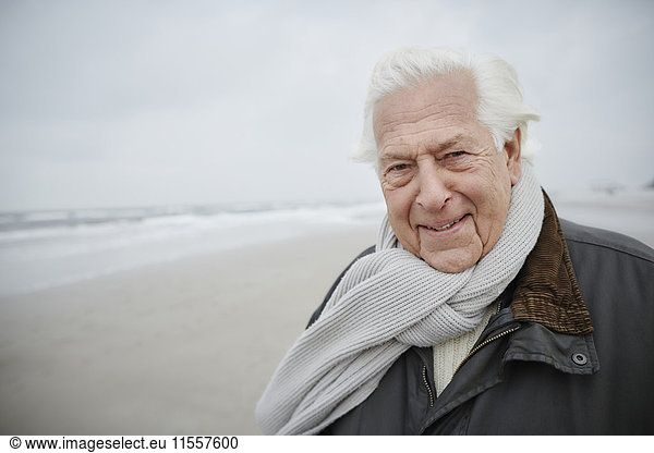 Portrait confident senior man wearing scarf on winter beach