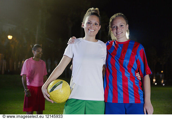 Portrait confident  smiling young female soccer teammates with ball