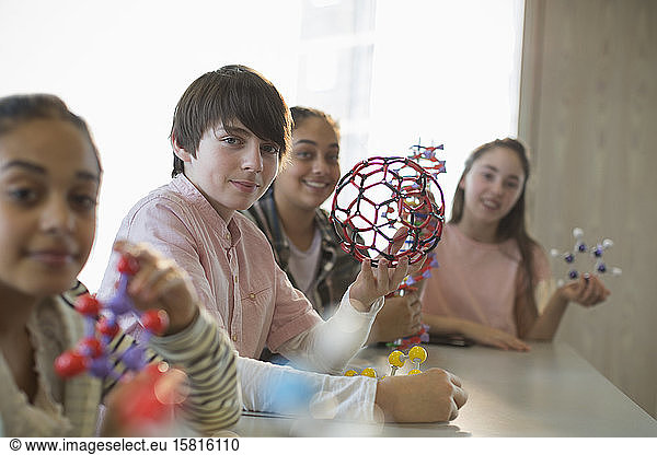Portrait confident students holding molecular structures in laboratory classroom