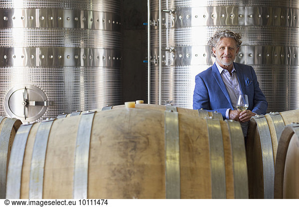 Portrait confident vintner in winery cellar